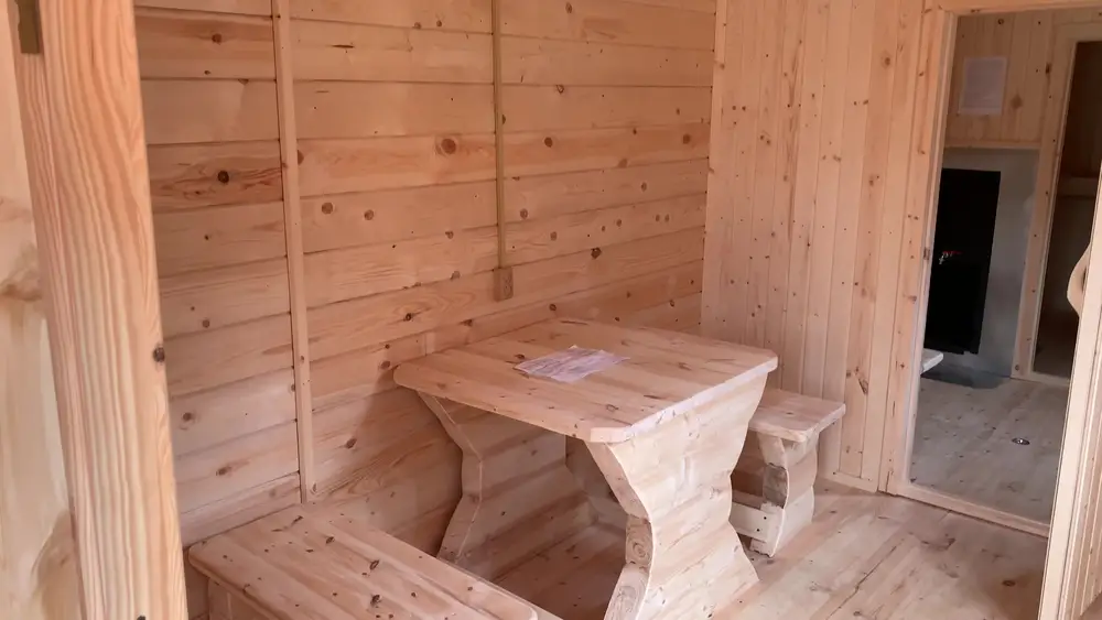 Просторный предбанник с переносным столом и двумя лавками в бане 2,3×8