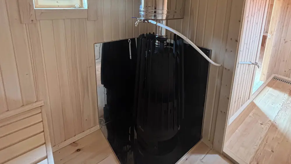 Печь Grill'D Cometa Vega Long в парной с баком на трубе и заводскими экранами по периметру