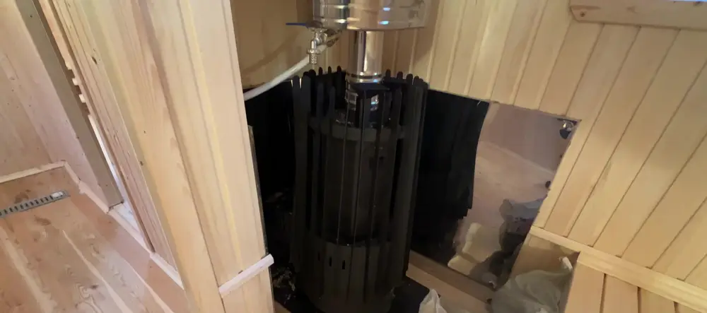Печь Grill'D Cometa Vega Long в парной мобильной бани: открытая каменка, бак для воды и экран из нержавеющей стали