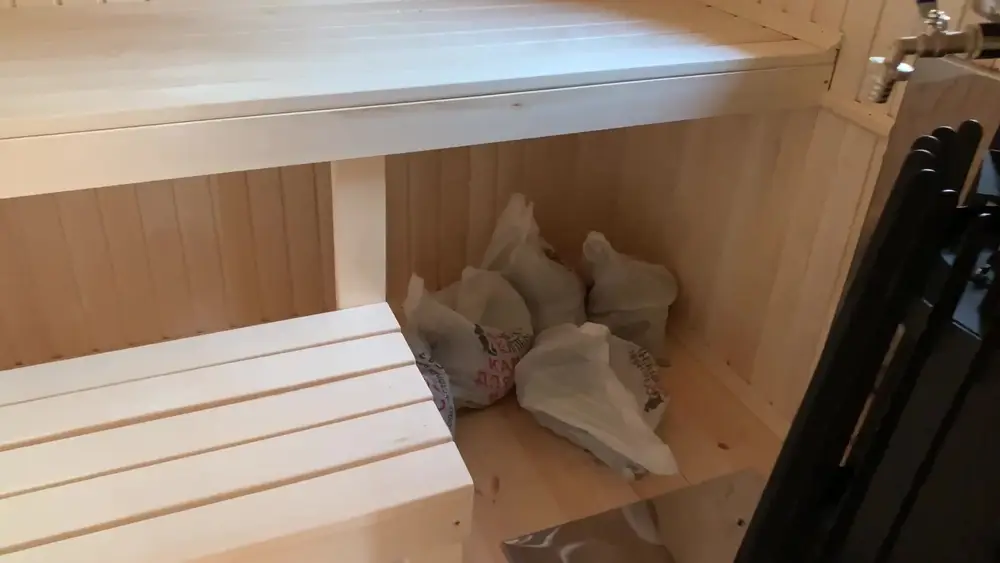 Двухъярусные полки в парной и упаковки с камнями под нижним полком рядом с печью