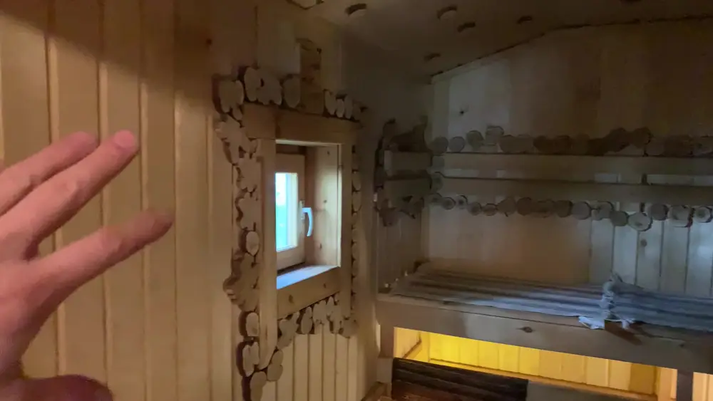 Резные деревянные элементы на стенах и полках парной каркасной бани, ручная работа