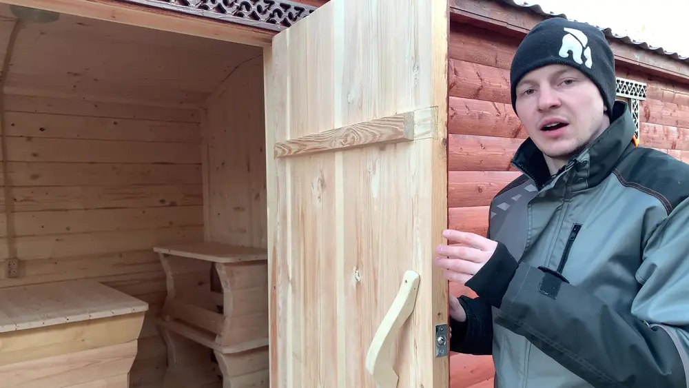 Клиновая дверь в парное отделение из цельной осиновой доски, открыта внутрь бани