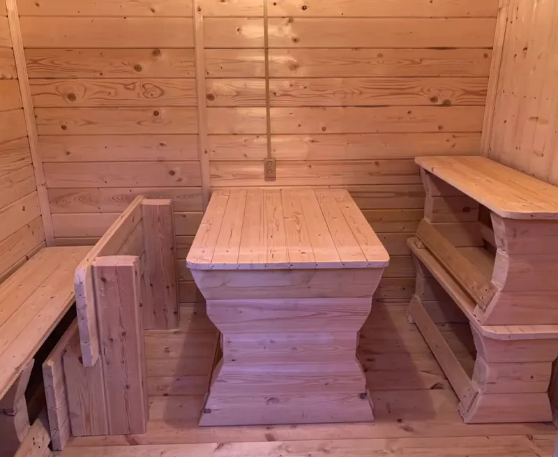 Комната отдыха в мобильной бане: лавки и стол из дерева
