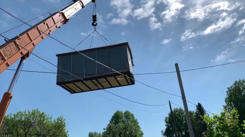 Доставка и установка мобильной бани — автокран разгружает баню на участке