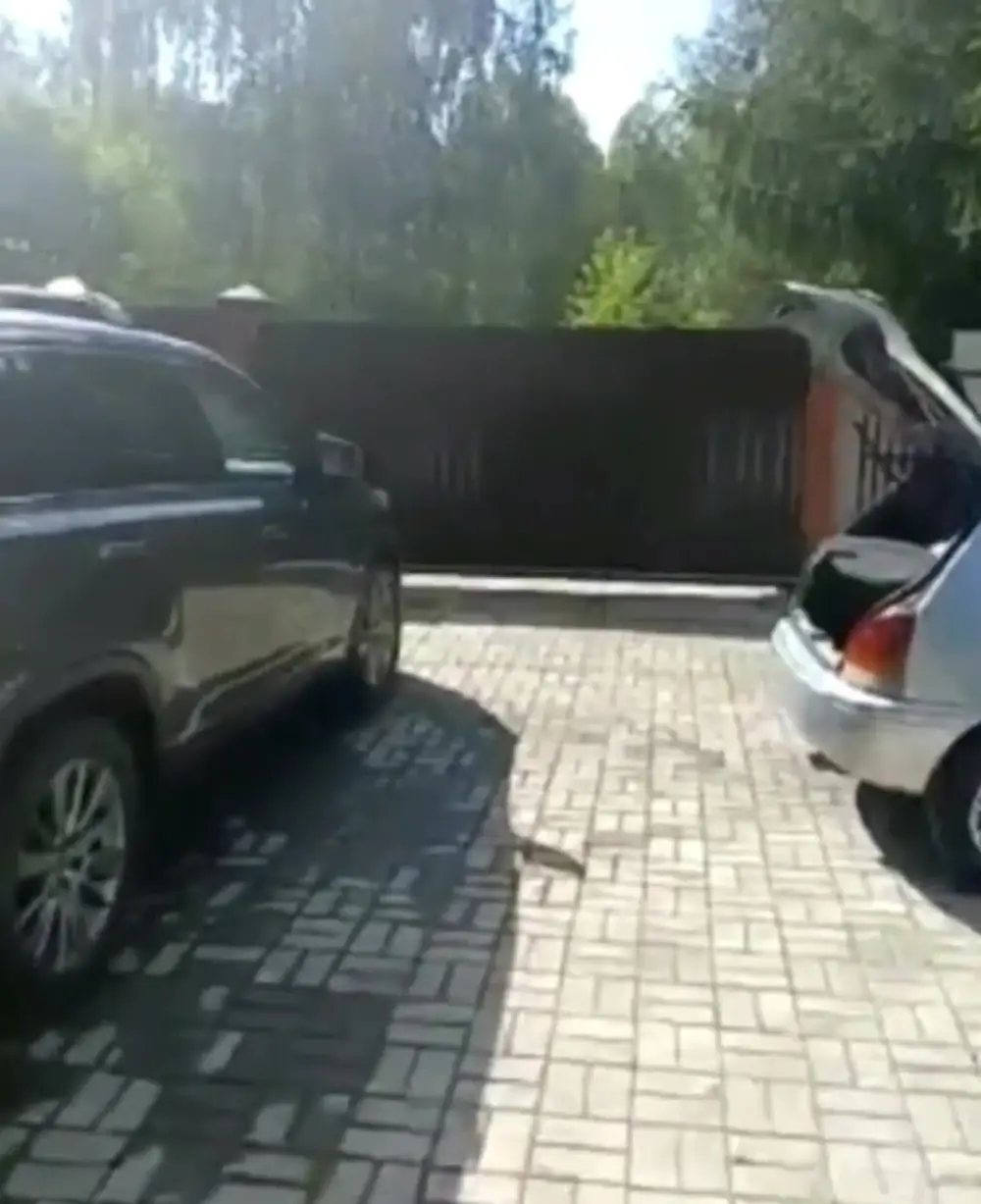 Двор заказчика с плиткой и двумя автомобилями возле ворот, место заезда крана для разгрузки бани