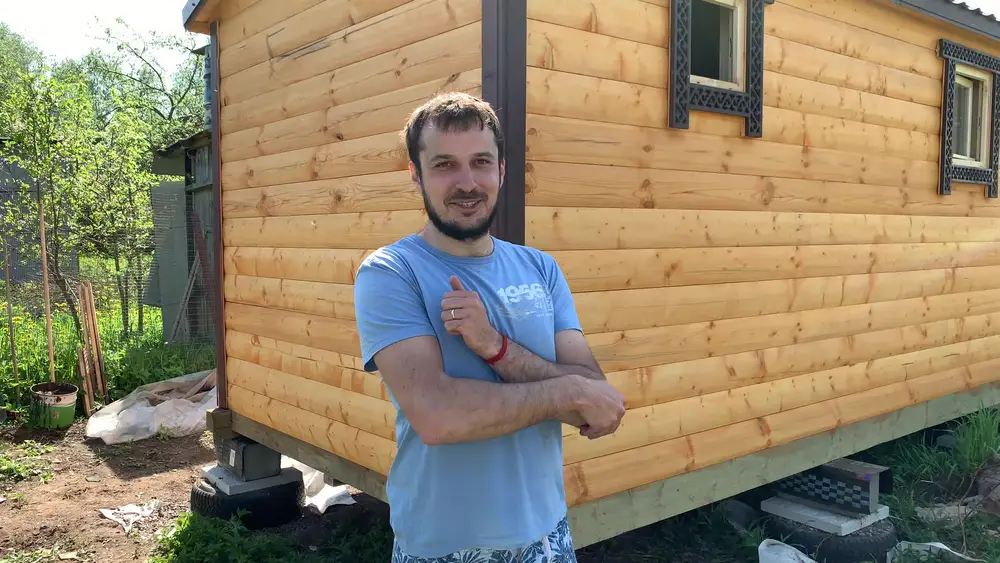 Заказчик у готовой перевозной бани из бруса в комплектации Максимум с резными наличниками на дачном участке