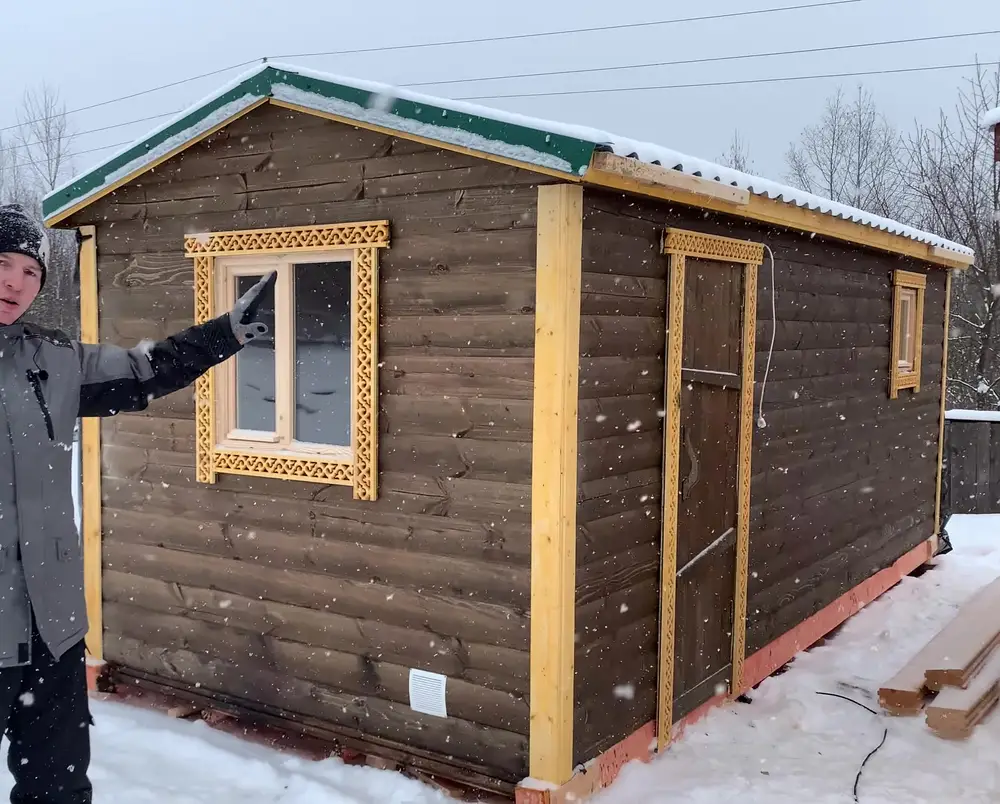 Мобильная баня 6 метров в цвете палисандр с резными наличниками на производственной базе зимой