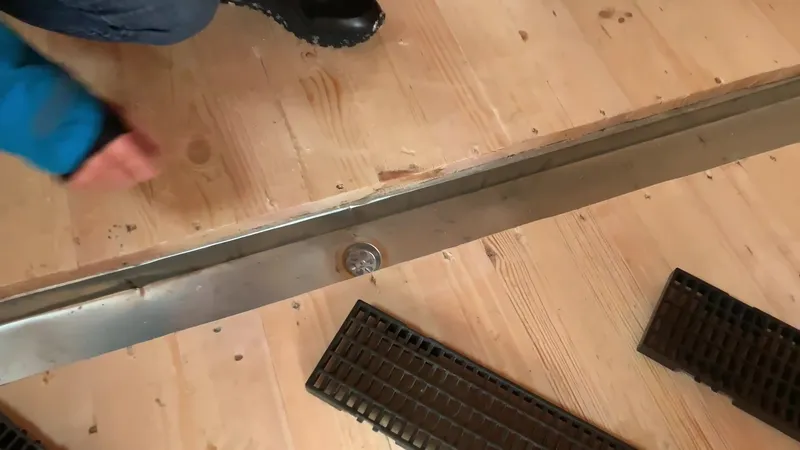 Желоб для слива воды в бане крупным планом — виден сифон