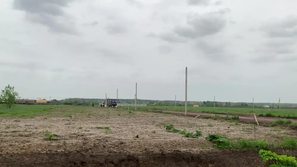 Широкая грунтовая дорога в населённом пункте, справа и слева канавы, подъезд к участку для установки бани