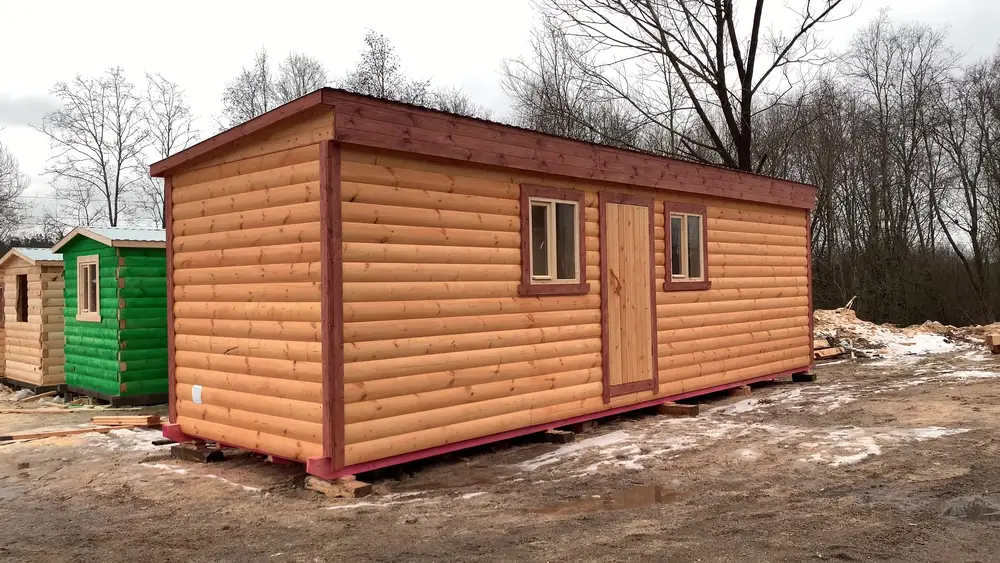 Утеплённая каркасная бытовка 2,3 на 7 метров с обшивкой блок-хаусом на производственной базе зимой