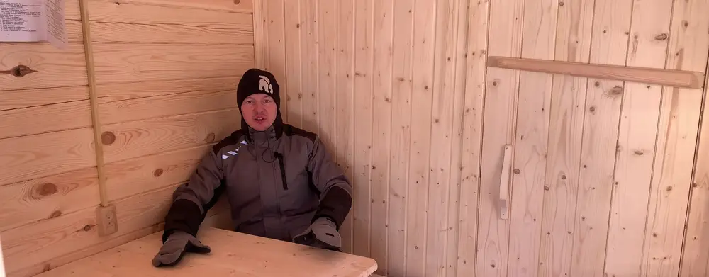 Предбанник зимней бани со столиком на лавочках для двух человек