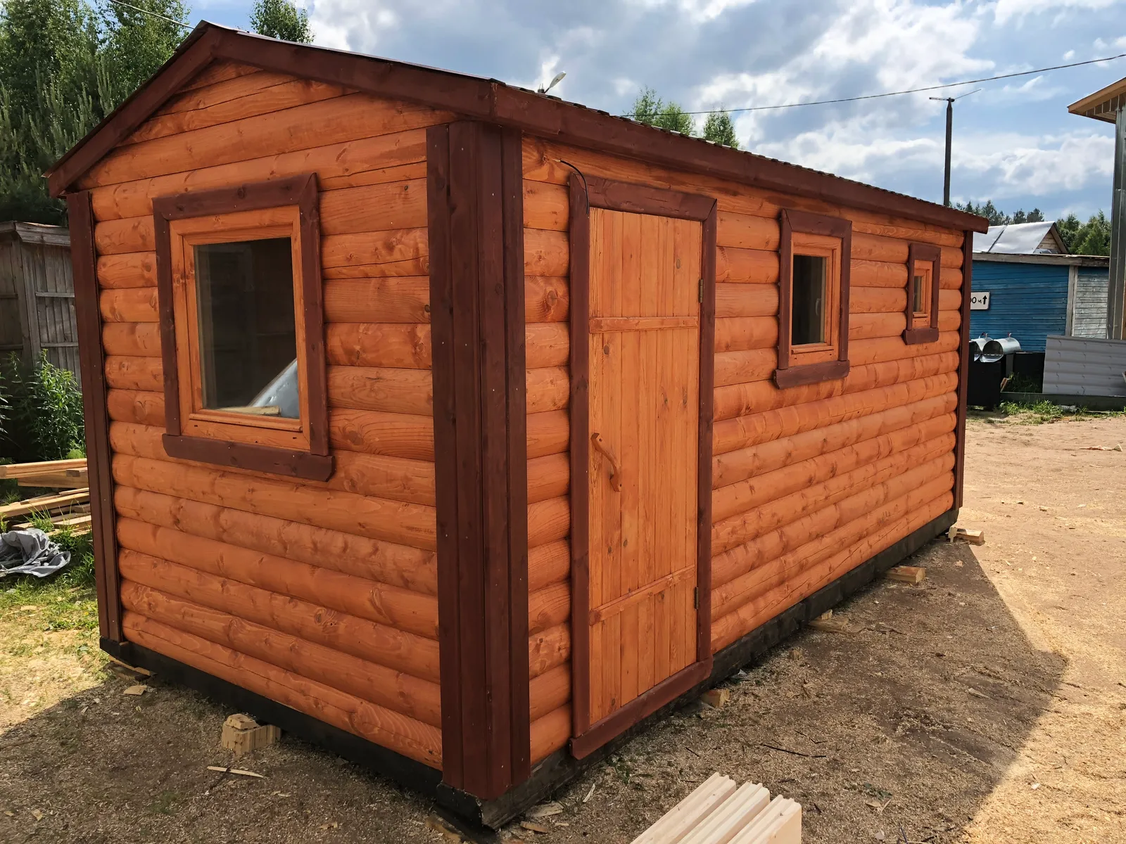 Баня из бруса 2,3×5 на производственной площадке — фасад с дверью и окнами