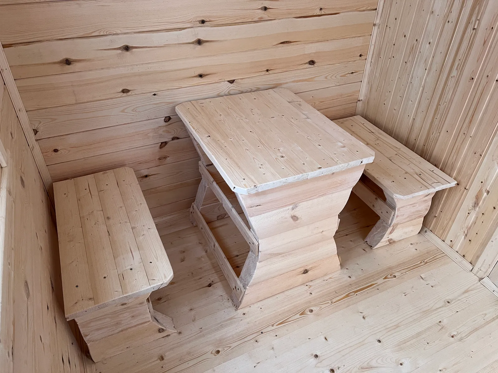 Комната отдыха бани 2,3×5 — деревянный стол и две лавки из массива