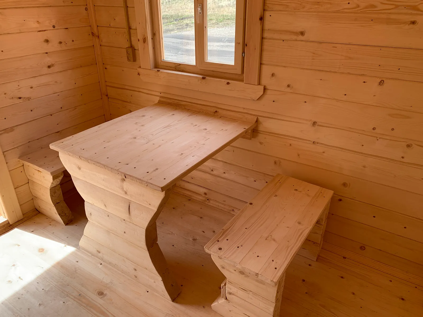 Комната отдыха бани 2,3×6 — стол и лавка из массива, окно с двойным остеклением