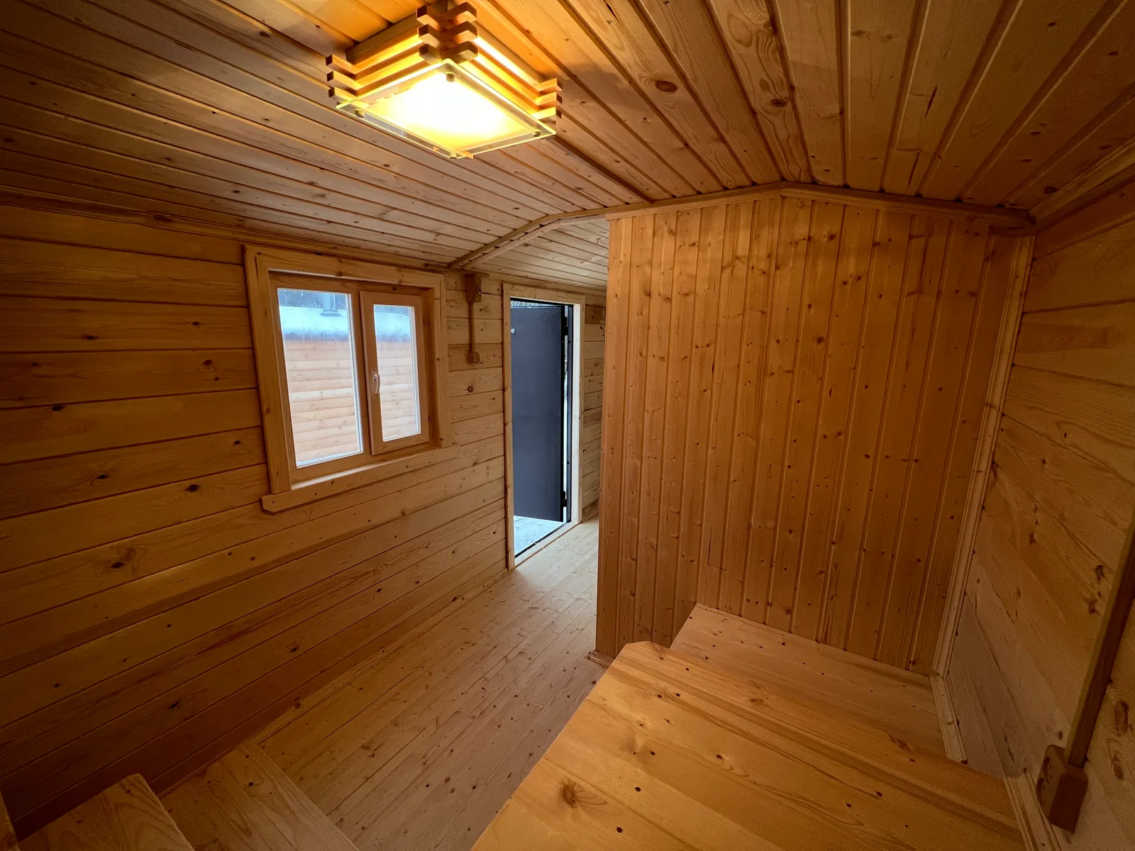 Комната отдыха бани 2,3×7 — просторное помещение, двойное окно, лавки вдоль стен